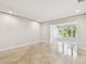 Bright living room with tile flooring and a doorway to a sunroom that brings in natural light at 2650 Countryside Blvd # B-110, Clearwater, FL 33761