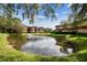 Scenic view of a pond surrounded by community buildings and lush green space at 2650 Countryside Blvd # B-110, Clearwater, FL 33761