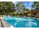 Community swimming pool surrounded by lush landscaping and seating areas at 2650 Countryside Blvd # B-110, Clearwater, FL 33761