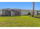 A spacious backyard with lush lawn and a screened patio, perfect for outdoor gatherings and relaxation at 27153 Capri Shores Cir, Englewood, FL 34223