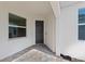 Covered entrance featuring a dark front door and brick flooring at 27153 Capri Shores Cir, Englewood, FL 34223