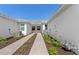 View of the landscaped walkway leading to the front of the home at 27153 Capri Shores Cir, Englewood, FL 34223