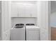 Convenient laundry room with white cabinets and modern washer and dryer units at 27153 Capri Shores Cir, Englewood, FL 34223