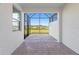 Covered patio featuring brick flooring and a screened enclosure with views of the lush landscape at 27153 Capri Shores Cir, Englewood, FL 34223