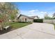 Single-story home with an expansive driveway and partial privacy fence, complemented by a bench and mature trees at 2906 Beagle Pl, Seffner, FL 33584