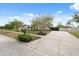 Single-story home with a well-maintained lawn, mature trees, an expansive driveway, and a partial privacy fence at 2906 Beagle Pl, Seffner, FL 33584