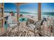 Charming balcony with a table and chairs overlooking the pristine sandy beach and sparkling ocean at 3 7Th Ave # 3, Indian Rocks Beach, FL 33785