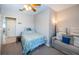Bedroom with a beach theme, ceiling fan, and a cozy sitting area with a gray couch at 3 7Th Ave # 3, Indian Rocks Beach, FL 33785