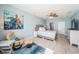 Bright main bedroom featuring a king bed, ceiling fan, and cool blue color scheme with a large colorful turtle art piece at 3 7Th Ave # 3, Indian Rocks Beach, FL 33785