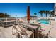 Outdoor pool and dining area with beach view, lounge chairs, and palm trees at 3 7Th Ave # 3, Indian Rocks Beach, FL 33785