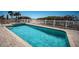 Outdoor pool with clear water, surrounded by a paved deck and white fence, near the beach at 3 7Th Ave # 3, Indian Rocks Beach, FL 33785