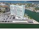 Aerial view of a high-rise condominium building with water views, parking, and boat docks at 31 Island Way # 609, Clearwater Beach, FL 33767