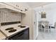 Classic kitchen with white appliances, adjacent to a dining area with chandelier lighting at 31 Island Way # 609, Clearwater Beach, FL 33767