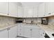 Well-lit kitchen featuring white cabinetry, modern appliances, and an eye-catching backsplash at 31 Island Way # 609, Clearwater Beach, FL 33767