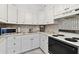 Well-lit kitchen featuring white cabinetry, modern appliances, and an eye-catching backsplash at 31 Island Way # 609, Clearwater Beach, FL 33767