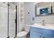 A modern bathroom featuring a walk-in shower and stylish vanity and mirror at 3604 Brigadoon Cir # 3604, Clearwater, FL 33759