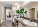 Elegant bathroom featuring dual sinks, modern fixtures, and a view into the bedroom at 37061 Sagemoor Dr, Zephyrhills, FL 33541