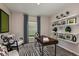 Bright home office space with a sleek wooden desk, stylish decor, and a large window for natural light at 37061 Sagemoor Dr, Zephyrhills, FL 33541