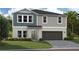 New construction home featuring a two-car garage, neutral color scheme, and an inviting front yard at 37073 Sagemoor Dr, Zephyrhills, FL 33541