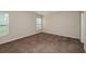 Neutral bedroom featuring carpet, natural light, and ensuite bathroom door at 37171 Sagemoor Dr, Zephyrhills, FL 33541
