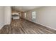 Spacious living room featuring wood-look flooring with lots of natural light that connects to the kitchen at 37171 Sagemoor Dr, Zephyrhills, FL 33541