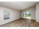 Open living room with hardwood floors and sliding glass doors to backyard at 37171 Sagemoor Dr, Zephyrhills, FL 33541