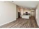 Open-concept living room features stylish wood floors and connects to a modern kitchen with stainless appliances at 37171 Sagemoor Dr, Zephyrhills, FL 33541