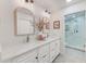Bright bathroom with dual sinks, stone counters, modern fixtures, and a view into the glass shower at 4212 Mill Valley Ct, Tampa, FL 33618