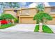 Charming home with beautiful trees, a well-manicured lawn, and an attached two-car garage at 4212 Mill Valley Ct, Tampa, FL 33618