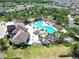 Beautiful aerial view of a community pool with palm trees, seating, and surrounding neighborhood at 4513 Eternal Prince Dr, Sun City Center, FL 33573