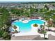 Stunning aerial view of a large community pool with palm trees and seating areas at 4513 Eternal Prince Dr, Sun City Center, FL 33573