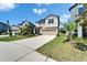 Well-kept two-story home with lush green lawn, palm trees, and spacious driveway on a sunny day at 4513 Eternal Prince Dr, Sun City Center, FL 33573