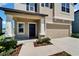 Inviting home entrance featuring a dark front door, manicured landscaping, and a two-car garage at 4513 Eternal Prince Dr, Sun City Center, FL 33573