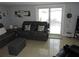 Cozy living room with tile flooring, comfortable seating, and sliding glass doors to the backyard at 4529 W Knox St, Tampa, FL 33614