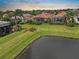 Aerial view of backyard, green grass, and a pond behind the home at 4917 Sandy Brook Crk, Wimauma, FL 33598