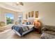 Bright bedroom features a comfortable bed, two windows with natural light, and unique wall art at 4917 Sandy Brook Crk, Wimauma, FL 33598