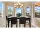 Bright breakfast nook with views and black table with four black chairs at 4917 Sandy Brook Crk, Wimauma, FL 33598