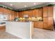 Bright kitchen features wood cabinets, tile backsplash, granite counters and island at 4917 Sandy Brook Crk, Wimauma, FL 33598