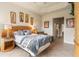 Main bedroom with tray ceiling, king bed, wood floors, and ensuite bathroom at 4917 Sandy Brook Crk, Wimauma, FL 33598