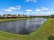 Scenic view of the tranquil pond surrounded by well-maintained lawns and lush landscaping at 4917 Sandy Brook Crk, Wimauma, FL 33598
