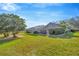 Expansive backyard showcasing a manicured lawn, screen porch, and mature trees, ideal for outdoor activities at 5212 Twin Creeks Dr, Valrico, FL 33596