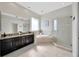 Bathroom featuring double vanity, soaking tub, and a glass enclosed shower at 5212 Twin Creeks Dr, Valrico, FL 33596