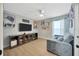 Bedroom with a large TV, ceiling fan, shelving, and a comfortable couch at 5212 Twin Creeks Dr, Valrico, FL 33596
