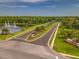 Beautiful aerial view of the River Hills community entrance, featuring manicured landscaping and a serene lake at 5212 Twin Creeks Dr, Valrico, FL 33596