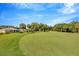 Scenic golf course featuring rolling green hills, mature trees, and a glimpse of a home in the background at 5212 Twin Creeks Dr, Valrico, FL 33596