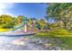 An outdoor playground with slides, climbing structures, and swings surrounded by trees and grass at 5212 Twin Creeks Dr, Valrico, FL 33596