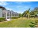 Scenic backyard view with a screened porch and lush greenery, perfect for relaxation at 5212 Twin Creeks Dr, Valrico, FL 33596