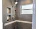 Shower featuring tile walls, storage shelving, and a shower head at 5212 Twin Creeks Dr, Valrico, FL 33596