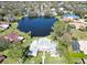 Aerial view of the lakefront home surrounded by lush greenery and mature trees at 5348 Saddlebrook Way # 2, Wesley Chapel, FL 33543