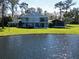 Back of home overlooking a pond and lush green lawn and screened porch at 5348 Saddlebrook Way # 2, Wesley Chapel, FL 33543